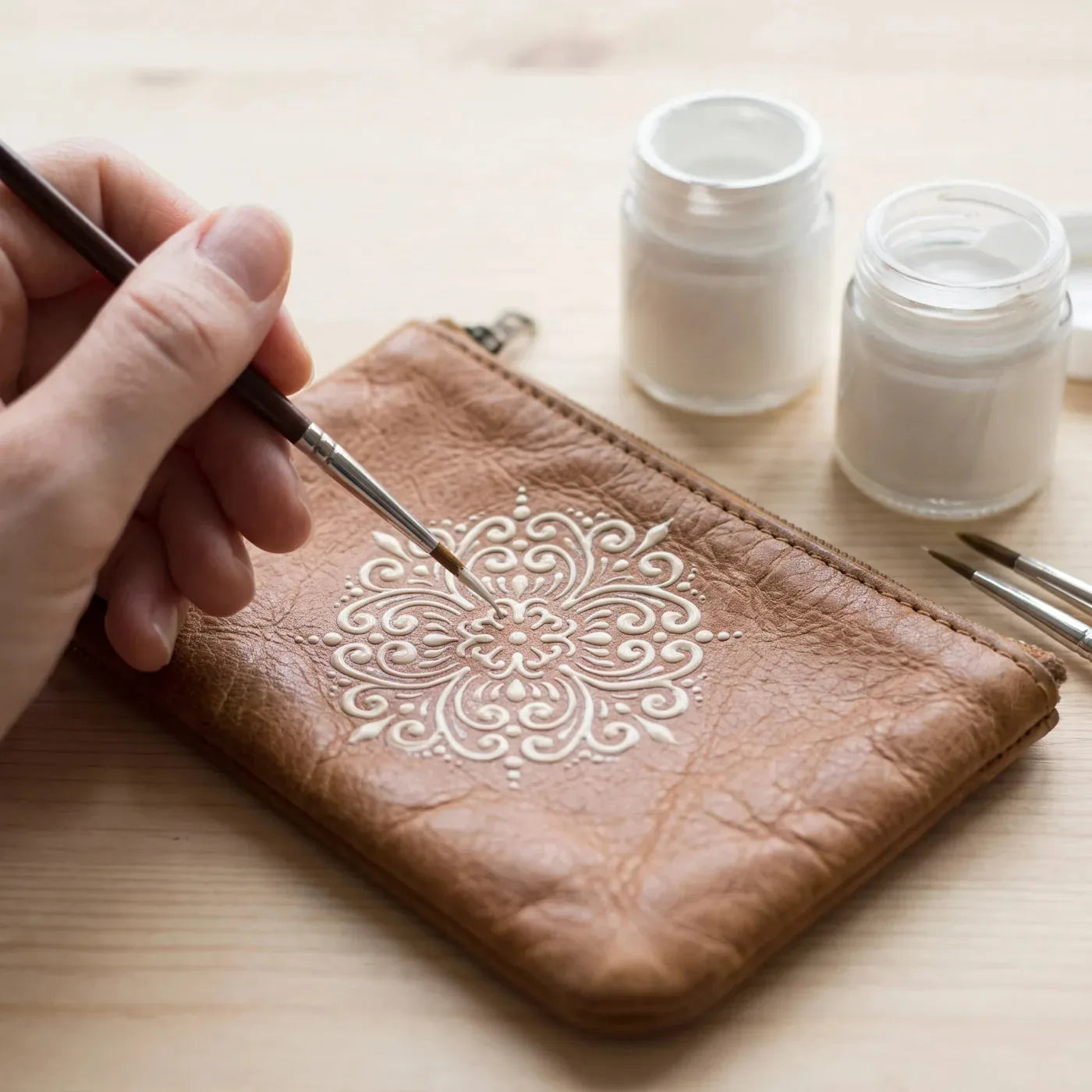 A solid-color ornament painted with fabric paint on a leather wallet